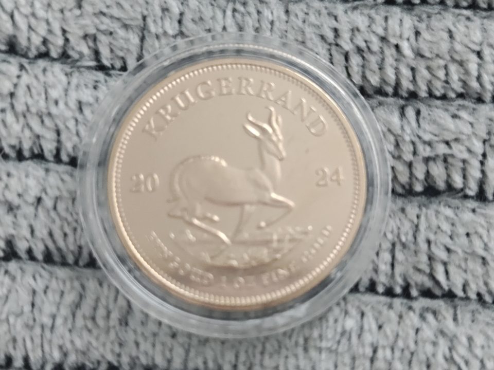 A collector coin in a capsule, photographed on fabric — the kind of photo worth stamping.